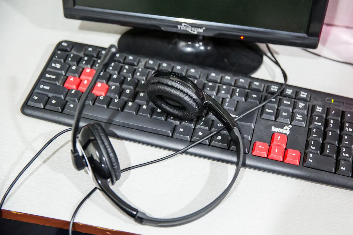 Headset resting on a keyboard at an agent workstation
