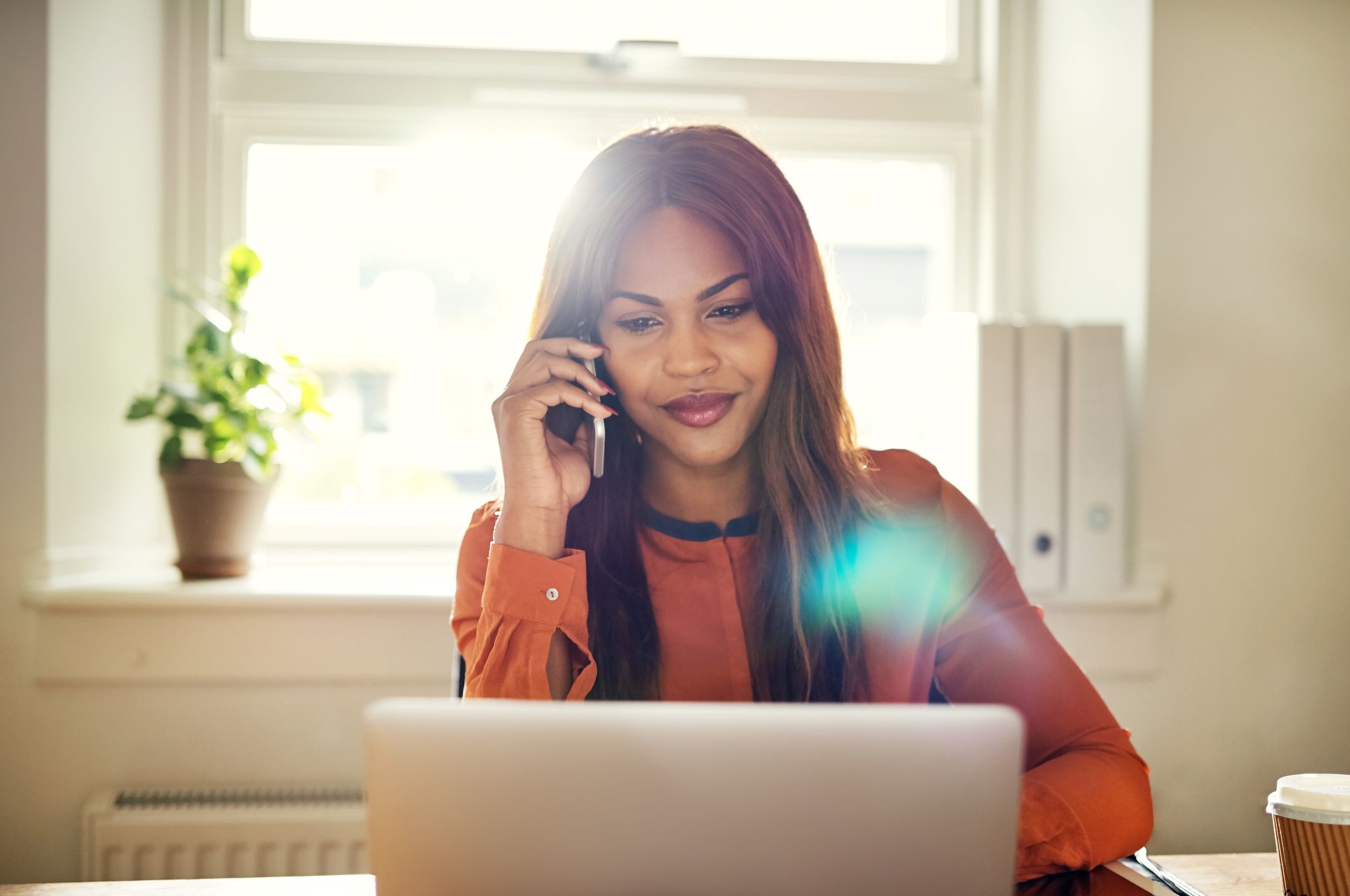 Person on a phone call while working at a laptop