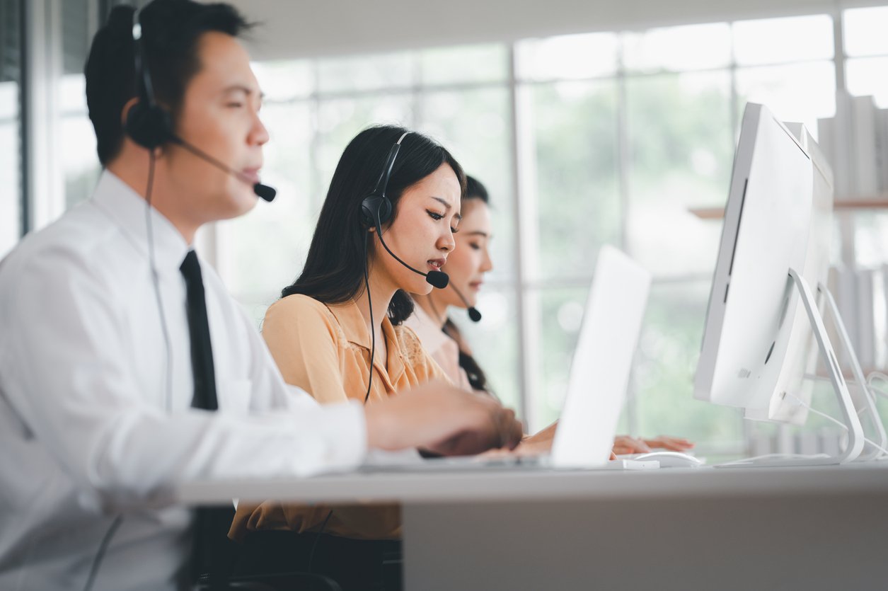 Row of contact center agents on headset calls